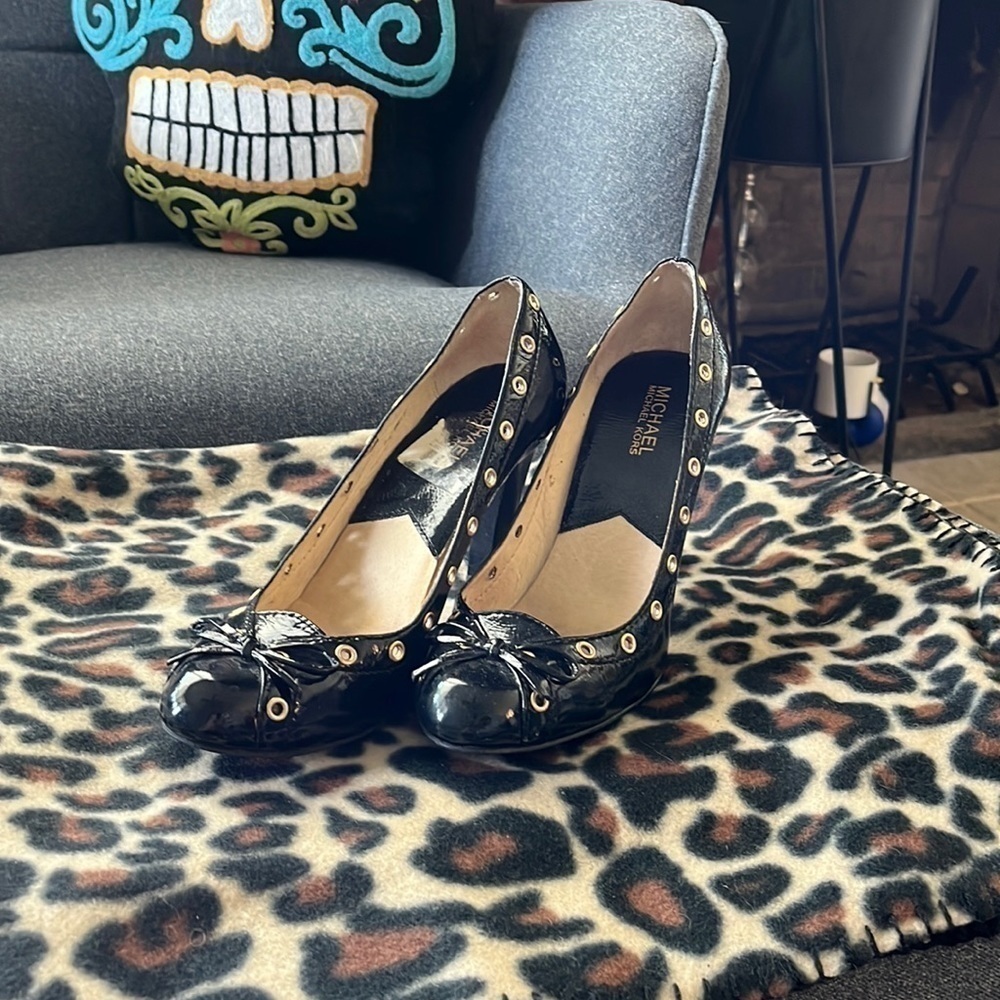 Michael Kors size 8 yes patent leather upper with gold grommet details.